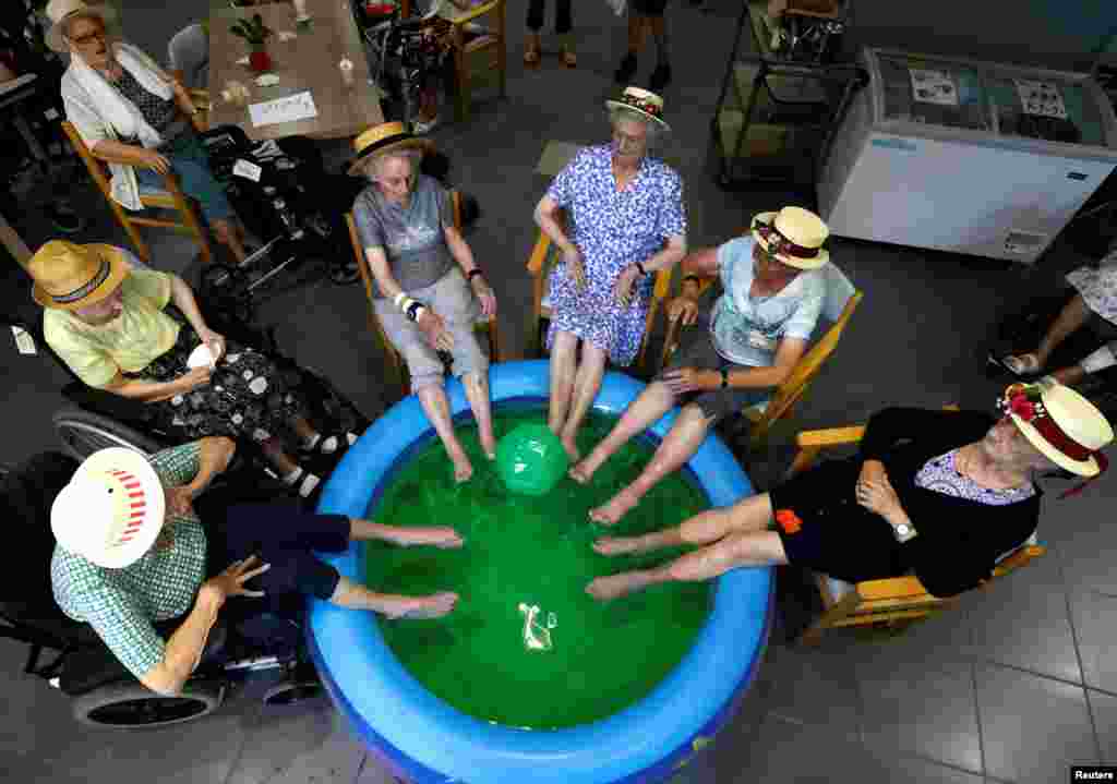 Residentes de&nbsp;Ter Biest,&nbsp;una vivienda para personas mayores, Rachel De Smedt, 89, Marie-Louise Buggenhout, 90, Mariette Van Dam, 90, Lisette Donies, 88 e Irma Van Buggenhout, 93, sumergen sus pies en una piscina en Grimbergen, Bélgica, el martes 19 de julio de 2022.