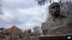 Вцілілий бюст Тараса Шевченка та вщент зруйнований будинок культури внаслідок російського авіаудару на село Бишів, неподалік Києва, 4 березня 2022 року. Фото: AP/Efrem Lukatsky
