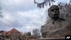 A bust of Taras Shevchenko, Ukrainian poet and national symbol, stands against the background of a house of culture ruined after a night air raid in the village of Byshiv, west of Kyiv, Ukraine, March 4, 2022. 