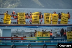 Sejumlah aktivis perempuan melakukan kampanye terkait perlindungan hak masyarakat adat dan menolak deforestasi di kawasan Danau Toba, Sumatra Utara. Rabu 20 Juli 2022. (Courtesy: Greenpeace Indonesia)