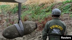 Members of the Italian army remove a World War II bomb that was discovered in the dried-up Po river which has been hit with the worst drought in 70 years, in Borgo Virgilio, Italy, Aug. 7, 2022.