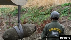 Anggota dari pasukan tentara Italia memindahkan bom dari masa Perang Dunia II yang ditemukan di dasar sungai Po yang mengering pada 7 Agustus 2022. Sungai terlebut terletak di Borgo Virgilio, Italia. (Foto: Reuters/Flavio Lo Scalzo)