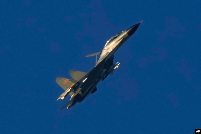 FILE - A Chinese J-11 military fighter jet flies above the Taiwan Strait near Pingtan, the closest land of mainland China to the island of Taiwan, in Pingtan in southeastern China's Fujian Province, Aug. 5, 2022. (AP Photo/Ng Han Guan)