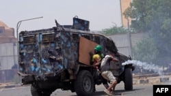 FILE - Sudanese anti-coup protesters clash with a riot police vehicle during a demonstration against military rule, in Khartoum, June 30, 2022. 