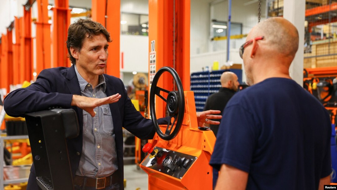 Perdana Menteri Kanada Justin Trudeau berbicara dengan salah satu pekerja di Pabrik Motrec International dalam kunjungannya ke pabrik pembuatan kendaraan listrik untuk industri itu di Sherbrooke, Quebec, Kanada, pada 12 Juli 2022. (Foto: Reuters/Evan Buhler)