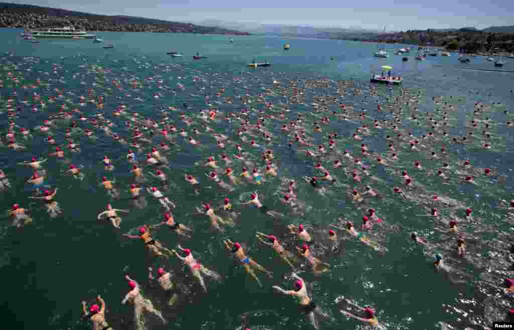 People take part in the annual public Lake Zurich crossing swimming event in Zurich, Switzerland.