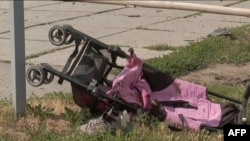 A stroller is seen lying on the ground after Russian missiles strike Vinnytsia, in central Ukraine, killing at least 20 people including three children, in this video grab taken from AFPTV footage July 14, 2022, and released July 15, 2022. 