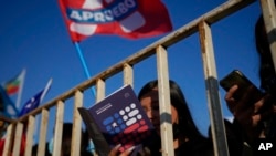 Una mujer lee un folleto de la propuesta de una nueva Constitución mientras participa en una manifestación a favor con miras al plebiscito del 4 de septiembre, en el barrio de Maipú de Santiago, Chile, el sábado 23 de julio de 2022. 