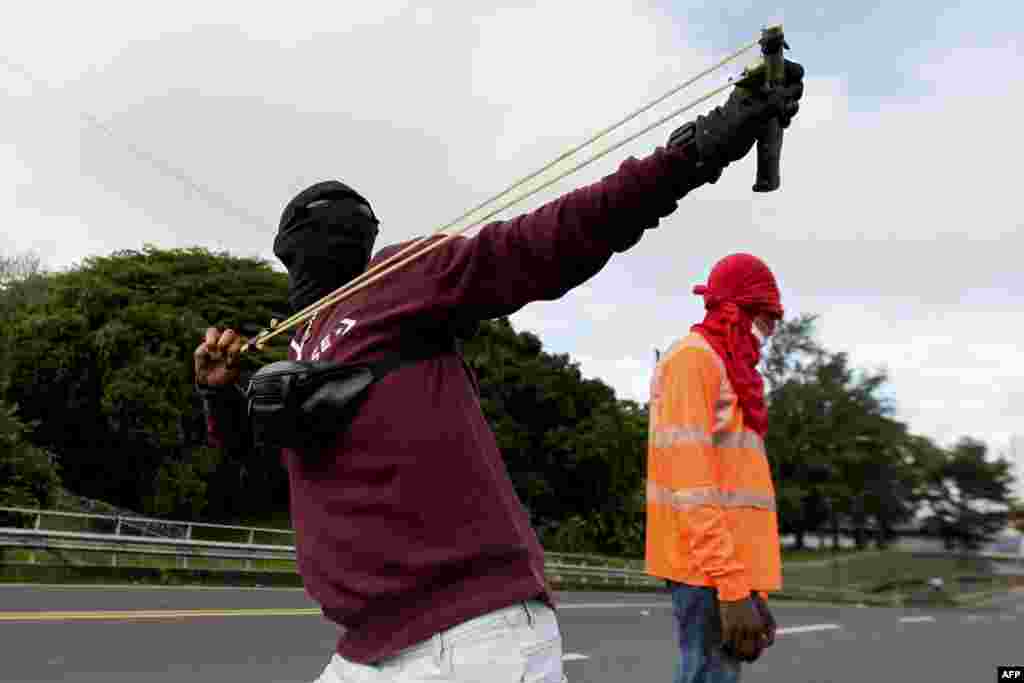 Un manifestante usa un objeto para lanzar contra la policía durante una protesta por el alto costo de los alimentos y la gasolina en la Ciudad de Panamá, el 11 de julio de 2022.