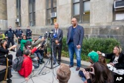 Ameen Johnson, left, and Shahid Johnson speak to the media in New York City on Thursday, November 18, 2021, outside a Manhattan court after a judge dismissed the conviction of their late father Khalil Islam in the assassination of civil rights leader Malc