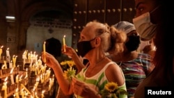Creyentes encienden velas en una iglesia en La Habana, Cuba.