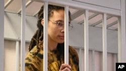 FILE - WNBA star and two-time Olympic gold medalist Brittney Griner stands behind bars in a courtroom prior to a hearing in the Khimki district court, just outside Moscow, Russia, Friday, July 15, 2022.