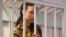 FILE - WNBA star and two-time Olympic gold medalist Brittney Griner stands behind bars in a courtroom prior to a hearing in the Khimki district court, just outside Moscow, Russia. Taken 7.15.2022
