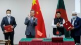 Chinese Foreign Minister Wang Yi, center left, and his Bangladeshi counterpart A.K. Abdul Momen applaud as both countries sign agreements in Dhaka, Bangladesh, Aug.7, 2022