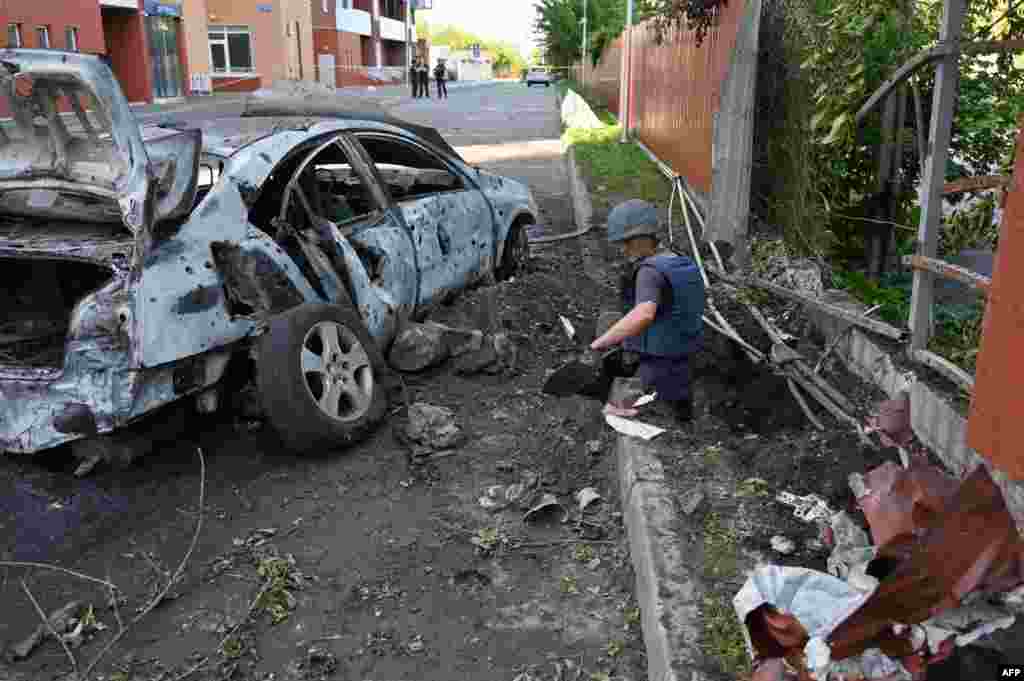 Deminers examine the site of a reported cluster munition fall after a rocket attack on a neighborhood in northern Kharkiv, Ukraine, during the Russian military invasion in Ukraine.