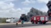 Smoke billows from a plane that flipped over after crash-landing, in Mogadishu, Somalia, July 18, 2022, in this screen grab from social media video obtained by Reuters.