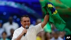Brazil's President Jair Bolsonaro holds a Brazilian flag during a rally to launch his reelection bid, in Rio de Janeiro, Brazil, July 24, 2022.