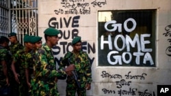 سربازان در برابر کاخ ریاست جمهوری سریلانکا، سه روز بعد از سقوط حکومت گوتابایا راجاپاسکا در اثر هجوم مقاومت‌ناپذیر مردم خشمگین. شعار روی دیوار می‌گوید «گوتا، برو خانه»