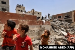 Anak-anak di tengah serangan udara Israel di Kota Gaza pada 6 Agustus 2022. (Foto: AFP/MOHAMMED ABED)