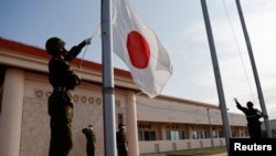 日本冲绳一个军营里的自卫队成员在晚间举行降旗仪式。（2022年4月20日）