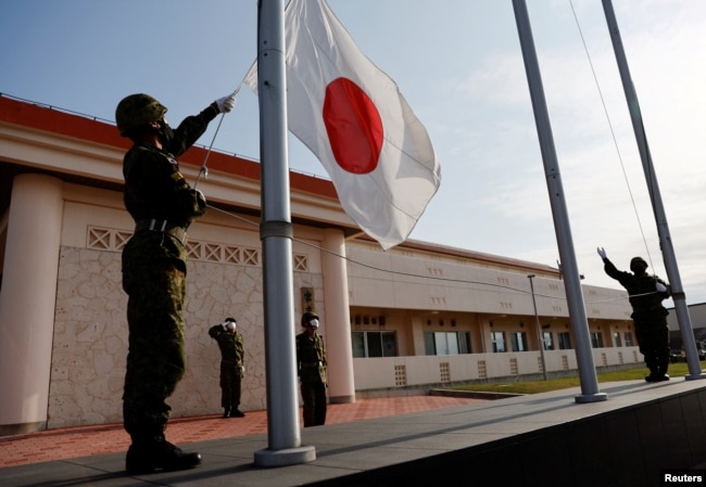 日本冲绳县宫古岛一个军营里的自卫队成员在晚间举行降旗仪式。（2022年4月20日）