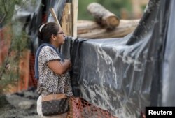 Laura Tijerina looks at the site of a coal mine, where a mine shaft collapsed leaving miners trapped, as she waits for news of her nephew Hugo Tijerina, a 29-year-old miner, in Sabinas, Coahuila state, Mexico, Aug. 6, 2022.