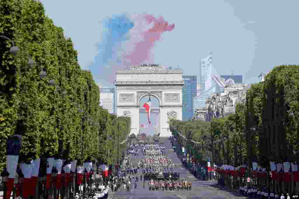 Members of the elite French&nbsp; acrobatic flying team &quot;Patrouille de France&quot; (PAF) releases smoke in the colors of the French flag as they perform a fly-over during the Bastille Day military parade on the Champs-Elysees in Paris.