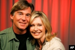 FILE - Olivia Newton-John and her husband John Easterling pose for a portrait in New York, April 2, 2009.