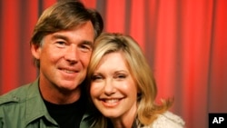 FILE - Olivia Newton-John and her husband John Easterling pose for a portrait in New York, April 2, 2009.