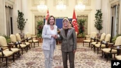 En esta foto proporcionada por el Ministerio de Comunicaciones e Información de Singapur, la presidenta de la Cámara de Representantes de los Estados Unidos, Nancy Pelosi, a la izquierda, y la presidenta de Singapur, Halimah Yacob, se dan la mano en el Palacio Presidencial de Istana en Singapur, el lunes 1 de agosto de 2022.
