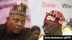 Mgombea urais wa chama tawala cha All Progressive Congress (APC) Bola Ahmed Tinubu (kulia) na Kashim Shettima wakizungumza wakati wa mkutano wa APC mjini Abuja Julai 20, 2022. Picha na Kola Sulaimon / AFP.