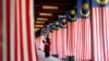 Seorang mahasiswa Universitas Nasional Malaysia berjalan melewati jajaran bendera nasional Malaysia di luar Kuala Lumpur 22 Agustus 2007. (Foto: Reuters/Bazuki Muhammad)