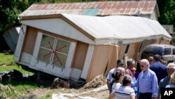 President Joe Biden tours a neighborhood impacted by flooding, Aug. 8, 2022, in Lost Creek, Kentucky. 