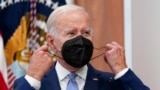 FILE - President Joe Biden removes his face mask as he arrives to speak about the economy during a meeting with CEOs in the South Court Auditorium on the White House complex in Washington, July 28, 2022.