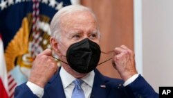 FILE - President Joe Biden removes his face mask as he arrives to speak about the economy during a meeting with CEOs in the South Court Auditorium on the White House complex in Washington, July 28, 2022.