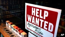 FILE: A help-wanted sign hangs in the front window of the Bar Harbor Tea Room, Saturday, June 11, 2022, in Bar Harbor, Maine. 