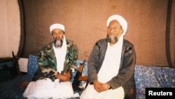 ئەیمەن زەواهیری سەرۆکی ڕێکخراوی ئەلقاعیدە لەگەڵ بن لادەن کە لە هێرشەکانی ئەمەریکا کوژران