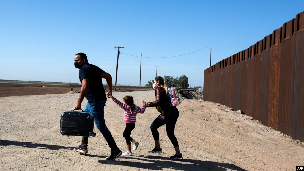  资料照片：来自古巴的一家三口移民跑过美国-墨西哥边界墙后向美国边境当局自首。(2021年5月1日)(photo:VOA)