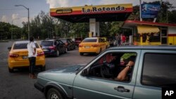 FILE: Drivers wait their turn to fuel their vehicles at a gas station in Havana, Cuba, July 14, 2022 