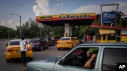 FILE: Drivers wait their turn to fuel their vehicles at a gas station in Havana, Cuba, July 14, 2022 