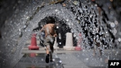 A child runs through a water fountain at Cinecitta World park, near Rome, Italy, July 23, 2022, during an ongoing heat wave across Europe. 