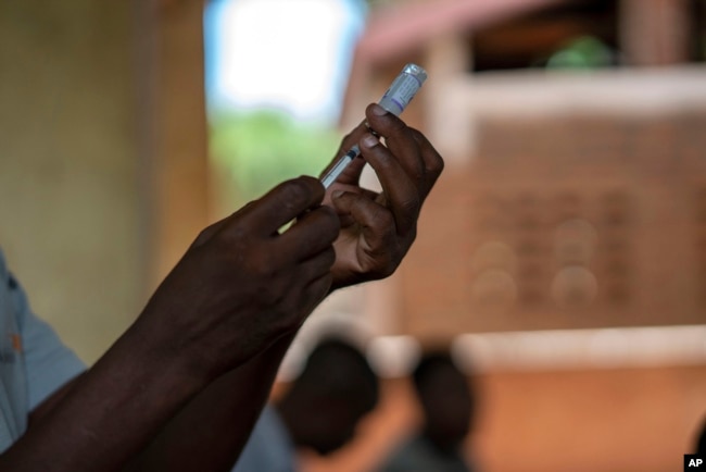 Health officials prepare to administer a vaccine in the Malawi village of Tomali with the world's first vaccine against malaria in a pilot program in Tomali, Dec. 11, 2019. (AP Photo/Jerome Delay, File)