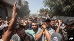 Mourners carry the bodies of Khaled Mansour, a senior commander in the Palestinian militant group Islamic Jihad, and other Palestinians who were killed in Israeli airstrike, during their funeral in Rafah, southern Gaza Strip, Aug. 7, 2022.