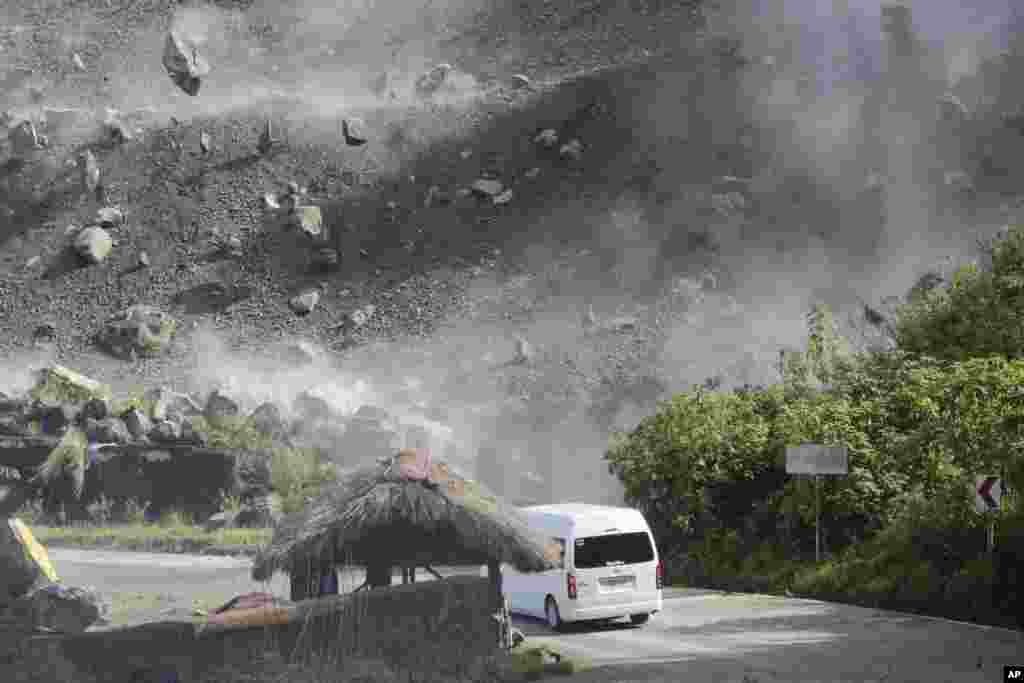 Pedregulhos caem enquanto um veículo passa por uma estrada durante um terramoto em Bauko, Província de Montanha, Filipinas, 27 de Julho de 2022.