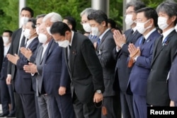 Perdana Menteri Jepang Fumio Kishida, pejabat dan karyawan berdoa di depan mobil jenazah mendiang mantan Perdana Menteri Jepang Shinzo Abe, di Tokyo, Jepang, 12 Juli 2022. (Foto: via Reuters)