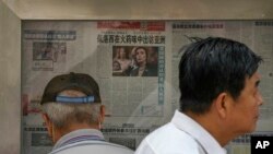 Men are seen at a newspaper display reporting on U.S. House Speaker Nancy Pelosi's Asia visit, at a stand in Beijing, China, July 31, 2022. 