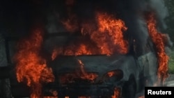 Une voiture brûle sur la route, non loin de la ligne de front, au milieu de l'attaque de la Russie contre l'Ukraine, dans la région du Donbass, Ukraine, le 16 juillet 2022.
