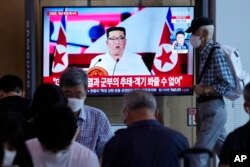 Warga menonton TV yang menampilkan pemimpin Korea Utara Kim Jong Un di sebuah program berita di Stasiun Kereta Api Seoul di Seoul, Korea Selatan, 28 Juli 2022. (Foto: AP)