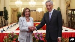 Nan foto sa a ke Ministe Kominikasyon ak Enfomasyon Sengapour la pataje ak lapres, Lide La Chanm Nancy Pelosi, a goch, poze pou yon foto ak Premye Minis Lee Hsien Loong nan Pale Prezidansyel la nan Sengapour, Lendi 1 Out, 2022. 