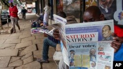 Un homme lit un journal dont la première page montre les principaux candidats à la présidence dans une rue du centre-ville de Nairobi, au Kenya, le 6 août 2022.